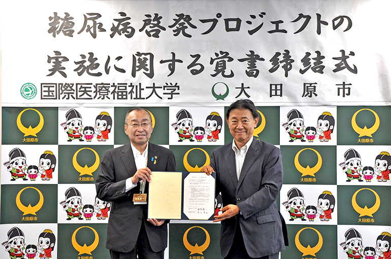 相馬憲一市長（左）と鈴木康裕学長（右）